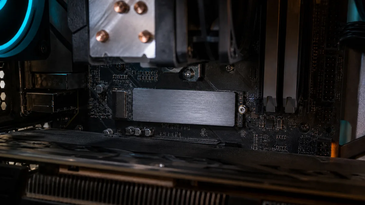 SSD M.2 NVMe instalado directamente sobre la tarjeta madre de una PC gamer, con disipador visible